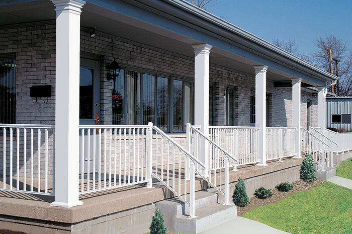 Duplex building with long front porch showcasing square white columns